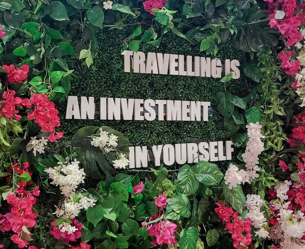 Tallikin terminaalissa oleva taideteos, jonka keskellä lukee "Travelling is an investment in yourself."